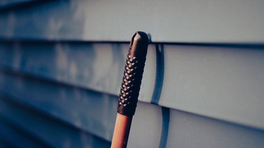7 Tips to Clean Vinyl Siding Without Professional Help 2 homeowner rinsing siding with hose