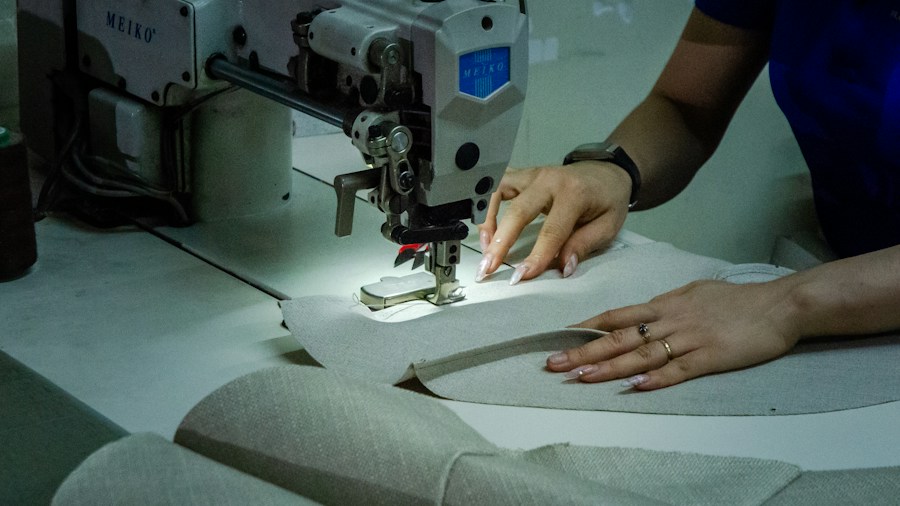 person sewing burlap fabric