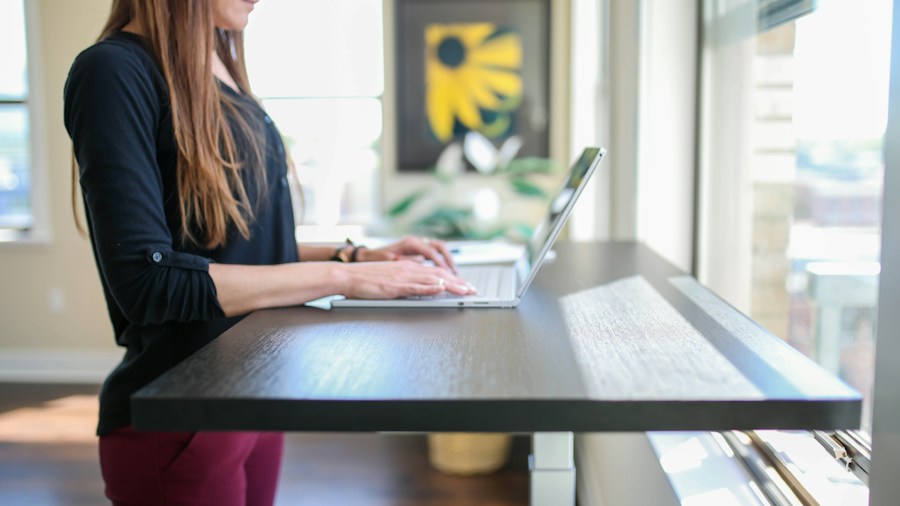 person working at adjustable standing desk